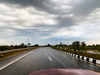 Fototapeta premium View of empty roads and cloudy sky while driving on a highway in the city