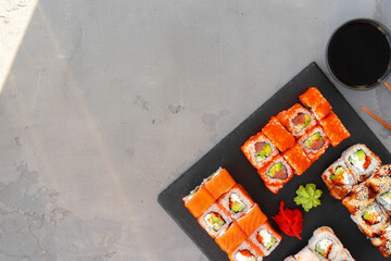 Set of sushi rolls served on gray background