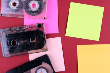 Three audio tapes with stickers on a colorful background. Retro technology