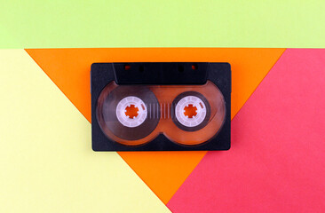 Black audio cassette close up on colorful background