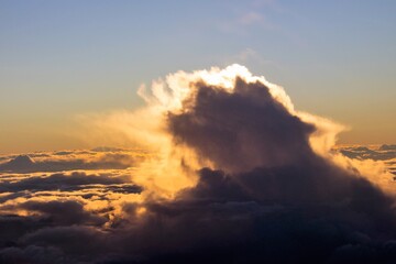 spectacular sunset seen from an airplane with clouds in the foreground and in the distance
