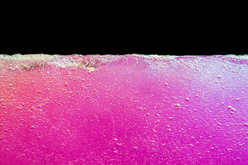 Pink bubbly boiling water against black background