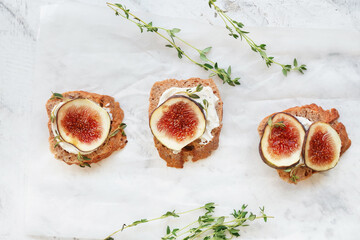 Tasty sandwiches with fig on light background