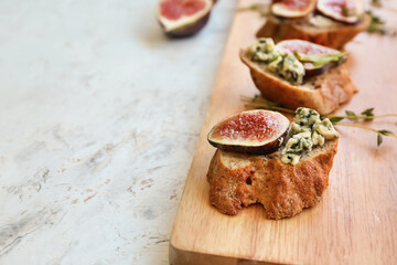 Tasty sandwiches with fig on light background