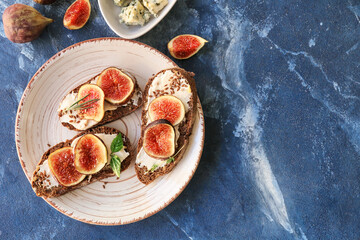 Tasty sandwiches with fig on color background