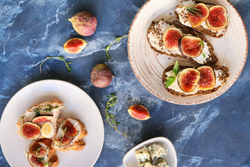 Tasty sandwiches with fig on color background