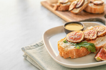 Tasty sandwich with fig on light background