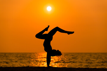 Fototapeta na wymiar Silhouette sport woman pose practice yoga exercise on sand beach in morning , yoga is meditation heathy sport concept.