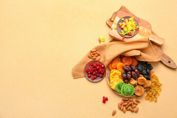 Plates with different dried fruits and nuts on color background