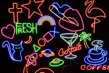 Neon assorted shapes on a black wall. Glowing multi-colored neon.