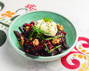 Beetroot salad with fresh greenery served in a bowl over traditional Ukrainian tablecloth.