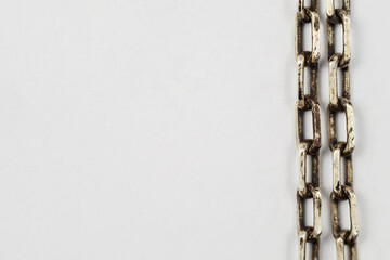 A closeup of an old silver chain. Dirty jewelry on a white background.