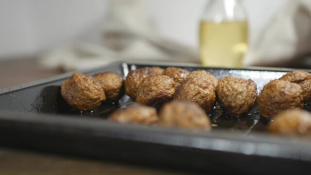 fried meatballs in a metal baking sheet on the table. Close-up. Filming Dolly.