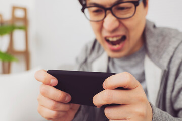 スマホでゲームをする男性