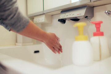 洗面所で手を洗う女性