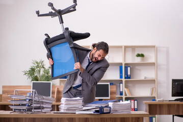 Young businessman employee unhappy with excessive work in the of