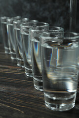 Shots of vodka on wooden background, close up