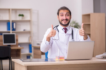 Young male doctor sitting in the office