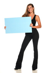 a young advertizing smiling woman in pants and a shirt holds empty board