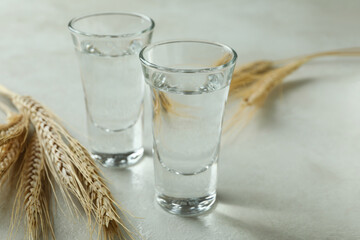 Shots of vodka and spikelets on white textured table