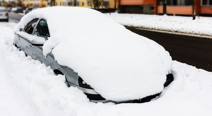 A snowy car on the street in winter