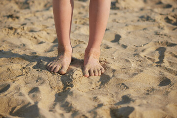 Fototapeta na wymiar 夏の海で砂遊びしている子供の足の様子