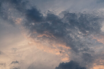 the blue clouds are illuminated by the setting sun