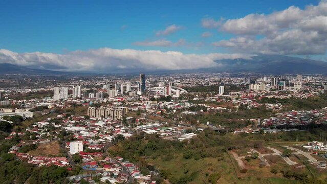 Beautiful cinematic aerial view of the city of San Jose  Costa Rica with view of the Sabana Park, and Churches 
