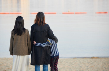 初夏の海で遊んでいる親子三人の姿