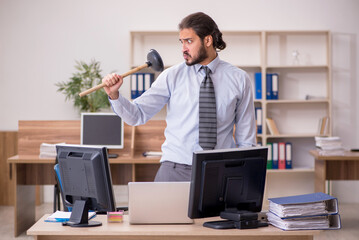 Young male employee holding plunger in funny concept