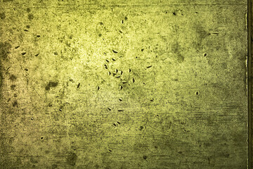 Scratches in a solid metal surface in green light.