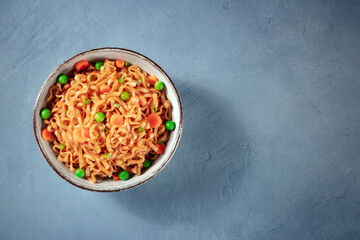 Noodles bowl on a blue background, top shot with copyspace
