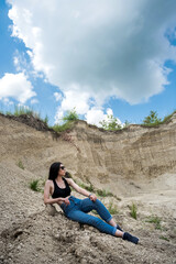 Naklejka premium Young lady in casual cloth relax on sand rocks