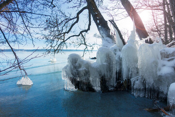 winter landscape with frozen icicles after a storm bey the lake