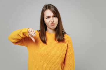 Young angry displesed unhappy dissatisfied caucasian woman 20s in casual knitted yellow sweater...