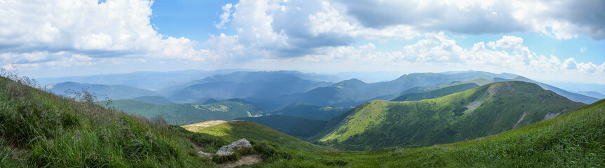 Fototapeta na wymiar Panorama of the Carpathian mountains. Hoverla peak on a sunny day with blue sky and white clouds