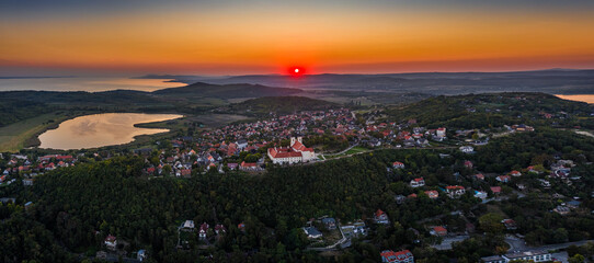 Tihany, Hungary - Aerial panoramic view of Benedictine Monastery of Tihany (Tihany Abbey, Tihanyi Apatsag) with Inner Lake and beautiful golden sky at sunset over Lake Balaton on a summer afternoon