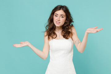 Confused puzzled bride young woman 20s in beautiful white wedding dress spreading hands say oops...