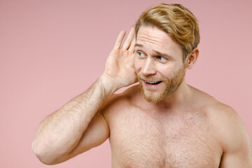 Obraz premium Curious bearded naked young man 20s perfect skin try to hear you overhear listen intently looking aside isolated on pink background studio portrait. Skin care healthcare cosmetic procedures concept.