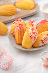 Delicious homemade chocolate dipped madeleine on white table background