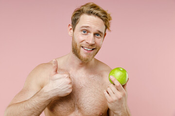Cheerful bearded naked young man 20s years old perfect skin hold green fresh apple fruit showing...