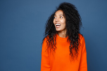 Excited cheerful laughing beautiful young african american woman wearing casual basic bright orange...