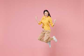 Full length of young smiling brunette excited overjoyed attractive latin woman 20s in yellow shirt...