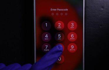 Enter passcode security system concept. Hand in medical glove entering digital code to unlock...
