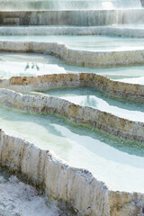 Picturesque view of natural white travertine terraces with hot springs in Pamukkale in Turkey
