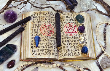 Open grimoire book of magic spells and ritual objects.
