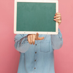 casual woman hiding her face behind a green board