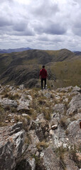 Naklejka premium boy standing looking at the landscape after climbing a mountain 