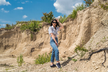 pretty girl in a casual cloth walks among the sands of the desert