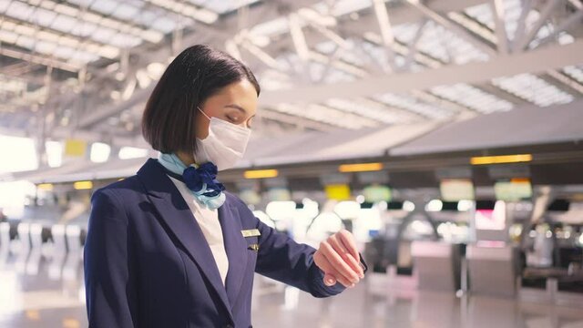 Air Hostess Wearing Face Mask, Checking Time For Flight In The Airport